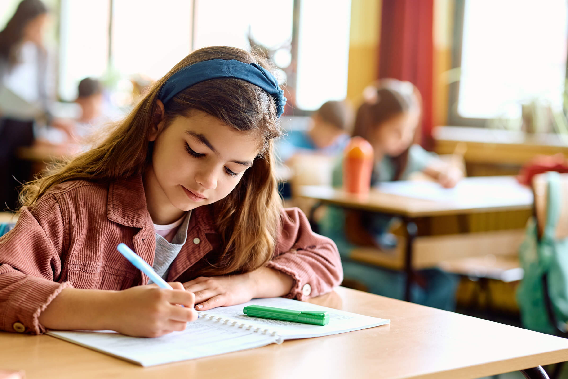 Student in classroom writing at desk